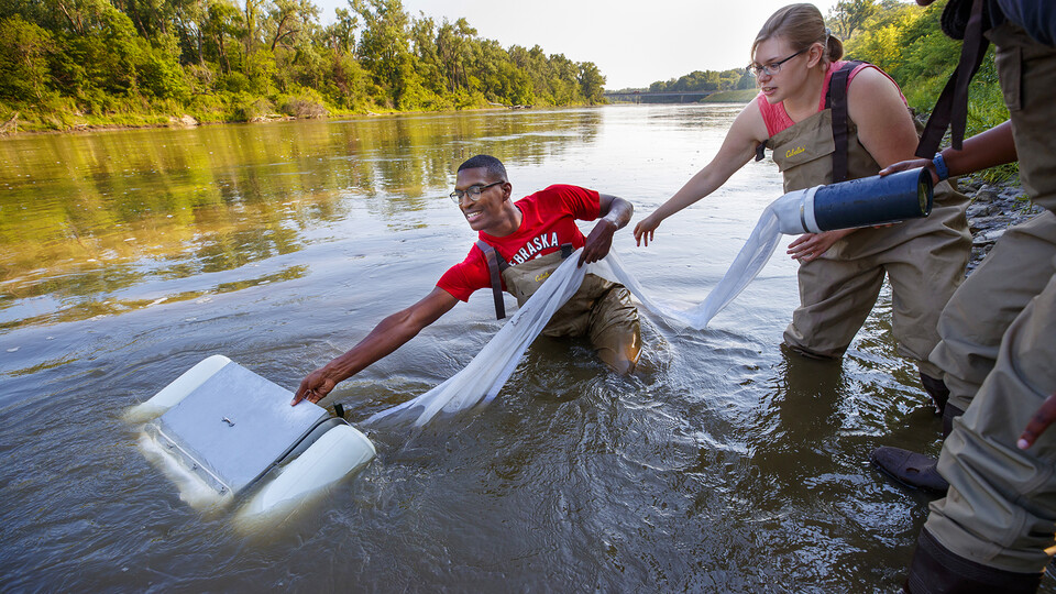 Students pulling equipment out of a river